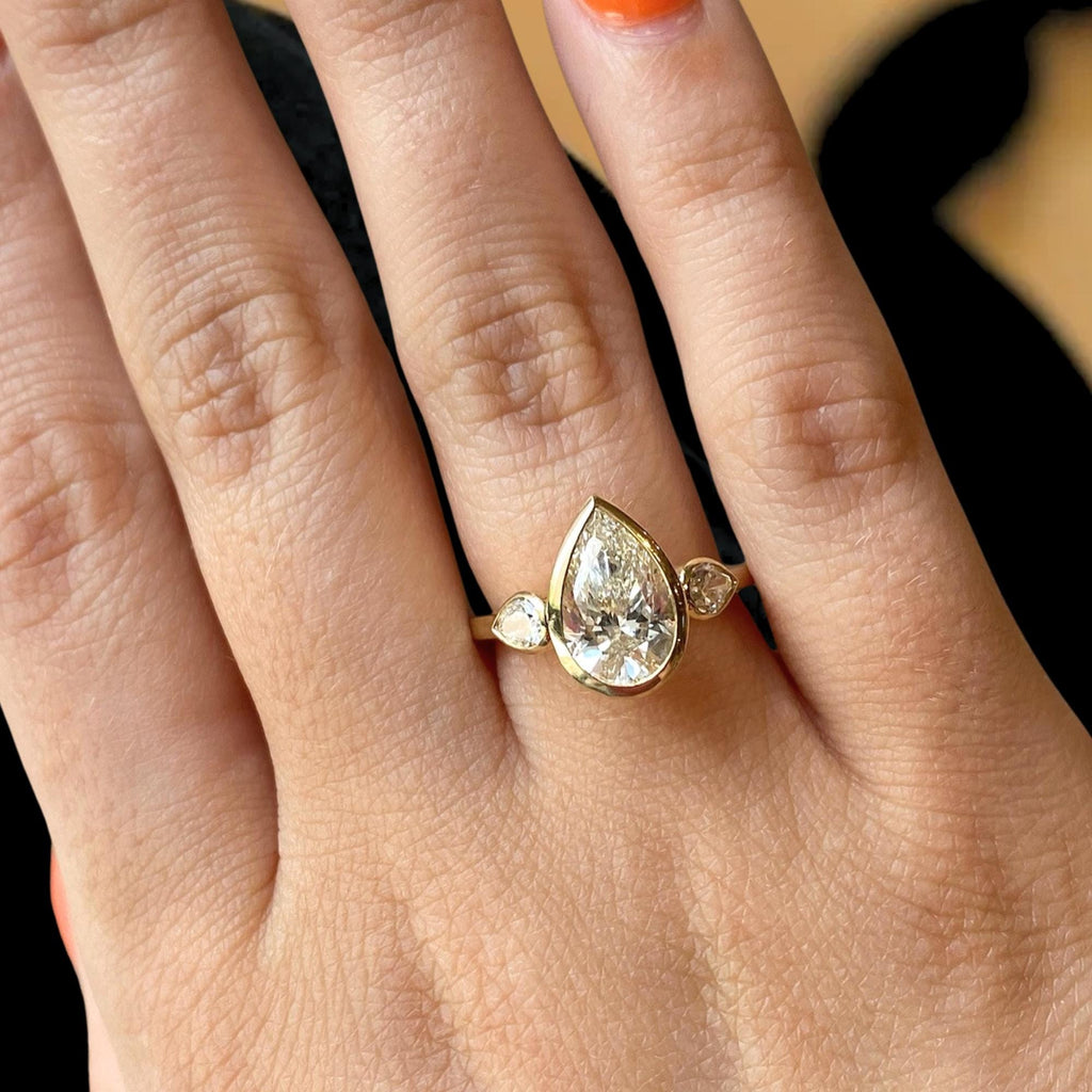2 Carat Pear Cut Lab Created Diamond Bezel Set Three Stone Ring With Hidden Halo