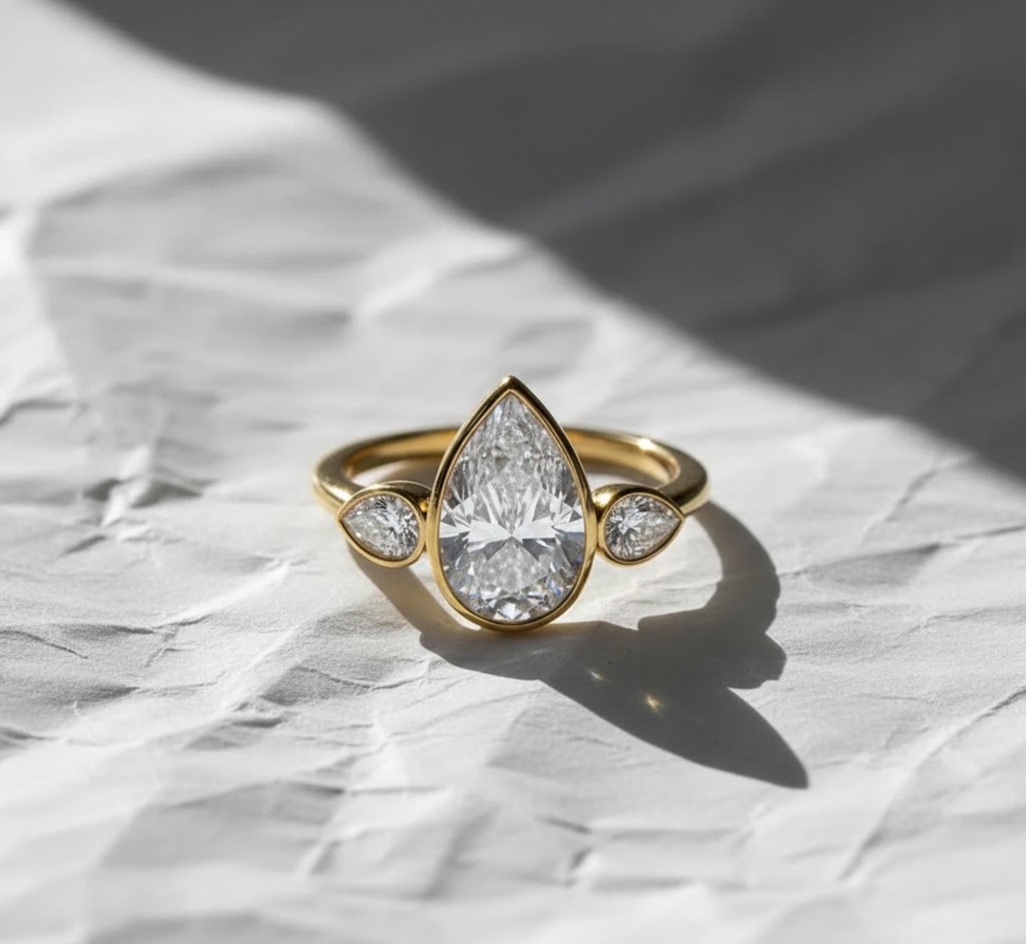 2 Carat Pear Cut Lab Created Diamond Bezel Set Three Stone Ring With Hidden Halo