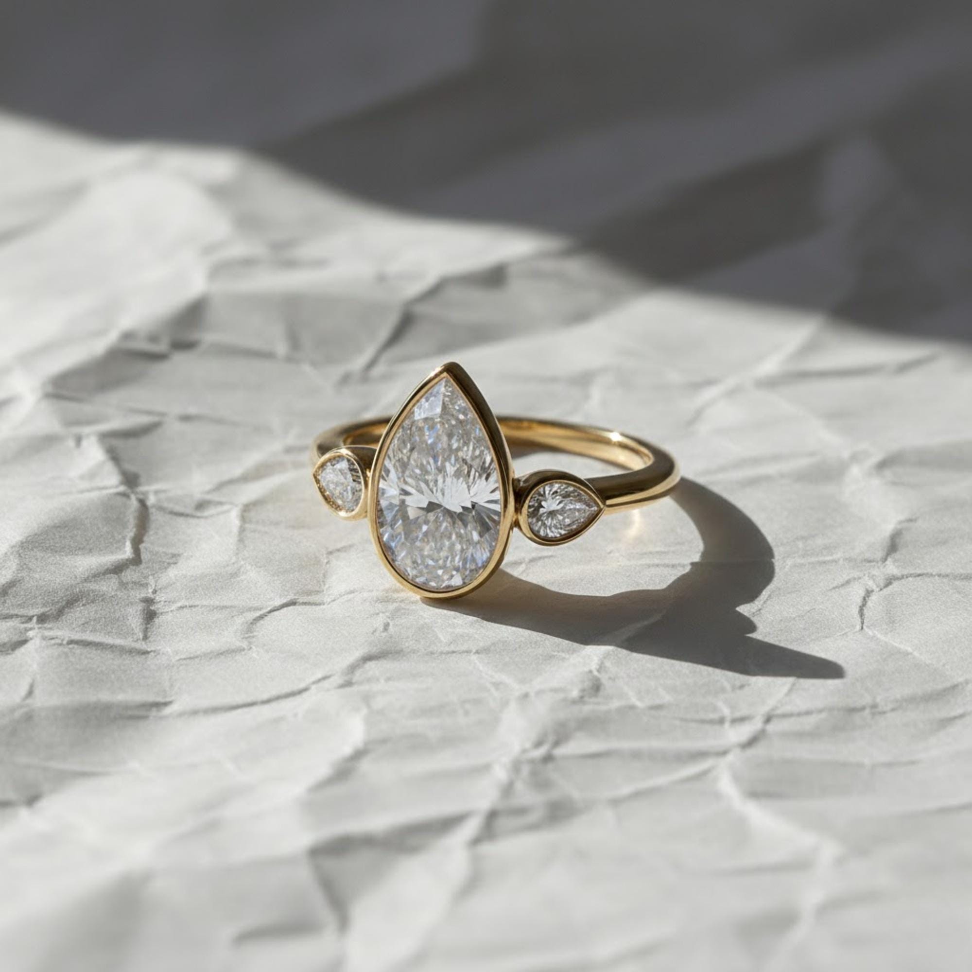 2 Carat Pear Cut Lab Created Diamond Bezel Set Three Stone Ring With Hidden Halo